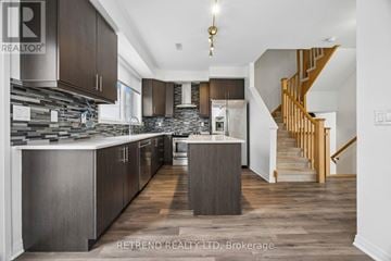 Toronto (Downsview-Roding-Cfb) townhouse for rent - A modern kitchen with dark wood cabinets and a stone backsplash.