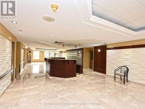 Mississauga (Cooksville) condo for rent - A reception area with a marble floor and a brown reception desk.