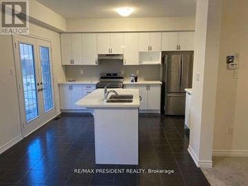 Brantford apartment for rent - A kitchen with white cabinets and a white island.
