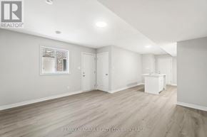 Welland (Dain City) apartment for rent - A spacious room with light wood flooring and white walls, with a window and a cabinet visible.