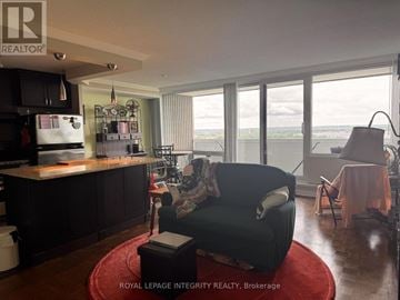 Ottawa condo for rent - A living room with a black couch and a red rug.