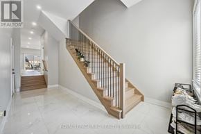 Welland (N. Welland) apartment for rent - A staircase with a wooden handrail and beige steps leads to a landing with a white wall.