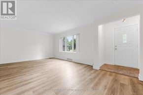 St. Catharines (Fairview) apartment for rent - A room with wooden flooring and white walls, with a door on the right side.
