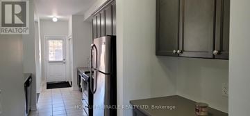 Brampton (Credit Valley) townhouse for rent - A kitchen with black cabinets and a white door.