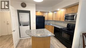Toronto condo for rent - A kitchen with a granite countertop and wooden cabinets.