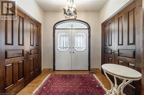 Stoney Creek apartment for rent - A room with a white table and a red rug in front of a white door with a black frame.