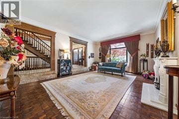 Stoney Creek apartment for rent - A living room with a rug in the middle and a staircase on the left.