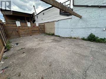 Toronto (Mount Dennis) apartment for rent - A backyard with a wooden fence and a sign that says "REALTOR".