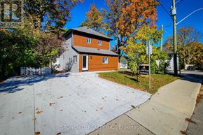 Woodstock (Woodstock - South) apartment for rent - A house with a brown and grey exterior is surrounded by trees with orange leaves.