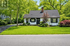 Burlington (Lasalle) apartment for rent - A white house with a black door and windows is surrounded by greenery.