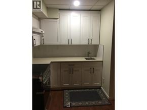 Coquitlam apartment for rent - A kitchen with white cabinets and a black mat on the floor.