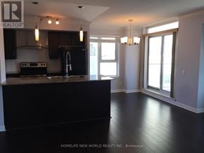 Toronto (Bendale) condo for rent - A kitchen with black appliances and a black island.