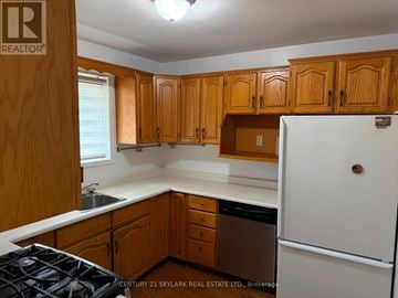 Brampton (Brampton North) apartment for rent - A kitchen with wooden cabinets and a white refrigerator.