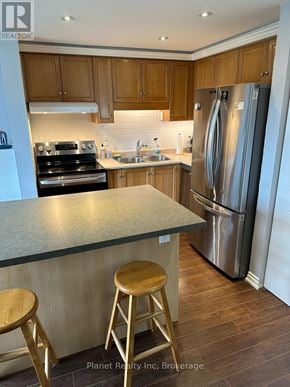 Guelph (Kortright West) townhouse for rent - A kitchen with wooden cabinets and a stainless steel refrigerator.