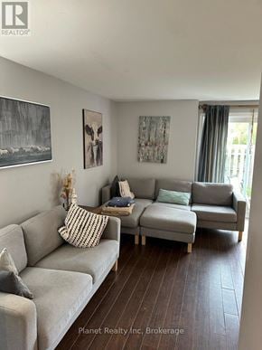 Guelph (Kortright West) townhouse for rent - A living room with a grey couch and a painting on the wall.
