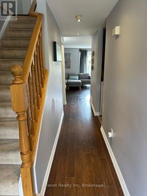 Guelph (Kortright West) townhouse for rent - A hallway with a staircase on the left and a living room on the right.