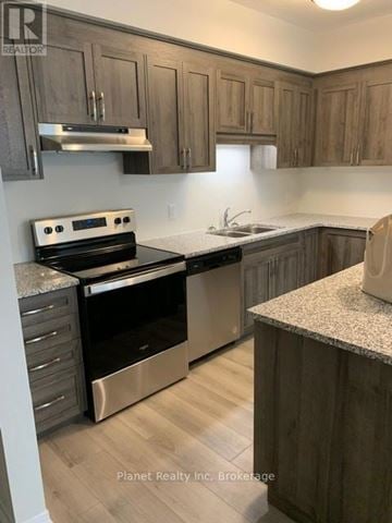 Kitchener townhouse for rent - A kitchen with wooden cabinets and a stainless steel oven.
