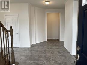 Caledon apartment for rent - A hallway with a tiled floor and a wooden staircase.