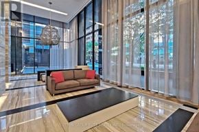 Toronto (Church-Yonge Corridor) condo for rent - A modern living room with a brown couch and a glass table.