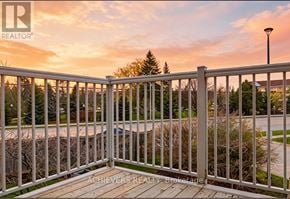 Barrie (Holly) condo for rent - A white railing with a view of a street and trees.