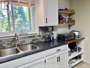 Quinte West (Trenton Ward) apartment for rent - A kitchen with a sink, a window, and a microwave.