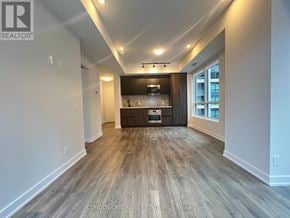 Toronto (Waterfront Communities) condo for rent - A spacious room with wood flooring and a bar area in the corner.
