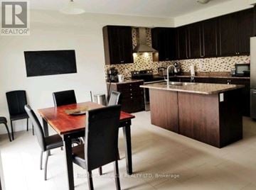 Niagara Falls (Brown) apartment for rent - A kitchen with a table and chairs in front of it.