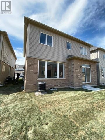 Brantford apartment for rent - A house with a brown and beige exterior is shown with a blue sky in the background.