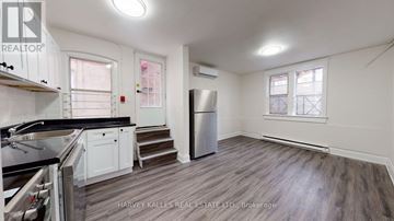 Toronto (Annex) multi-family for rent - A kitchen with a stove top oven and a refrigerator.