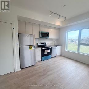 St. Catharines (E. Chester) townhouse for rent - A kitchen area with a refrigerator, microwave, and a dishwasher.
