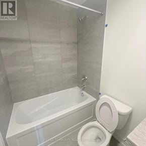 St. Catharines (E. Chester) townhouse for rent - A white toilet sits next to a white bathtub in a bathroom.
