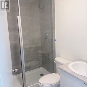 St. Catharines (E. Chester) townhouse for rent - A white toilet sits next to a walk-in shower.