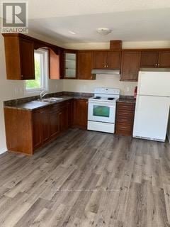 Oshawa (Vanier) multi-family for rent - A kitchen with wooden cabinets and a white fridge.