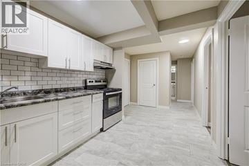 Cambridge apartment for rent - A spacious kitchen with white cabinets and a black stove top oven.
