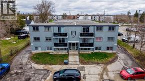 Cambridge apartment for rent - A grey apartment building with a parking lot in front.