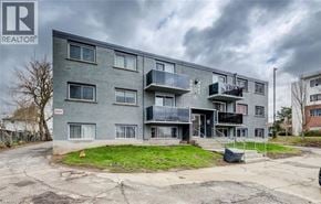 Cambridge apartment for rent - A grey apartment building with a cloudy sky in the background.
