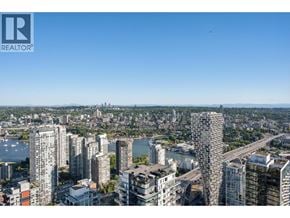 Vancouver apartment for rent - A cityscape with a clear blue sky and a body of water in the distance.