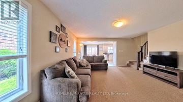 Kitchener townhouse for rent - A living room with a grey couch and a flat screen TV.