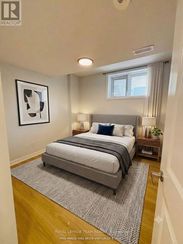 Ottawa townhouse for rent - A bedroom with a large bed and a framed picture on the wall.