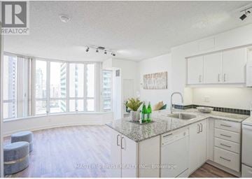 Toronto (Willowdale East) condo for rent - A kitchen with white cabinets and a granite countertop.
