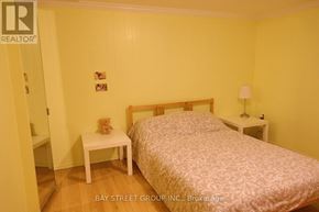 Markham (Royal Orchard) apartment for rent - A bedroom with a bed, nightstand, and chair.