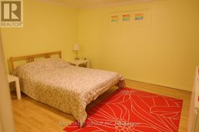 Markham (Royal Orchard) apartment for rent - A bedroom with a bed, a lamp, and a spider web rug.