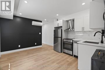 London South (South J) multi-family for rent - A modern kitchen with white cabinets and stainless steel appliances.