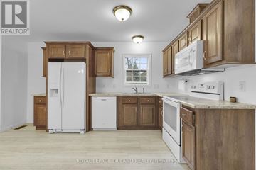 Central Huron (Clinton) apartment for rent - A kitchen with wooden cabinets and white appliances.