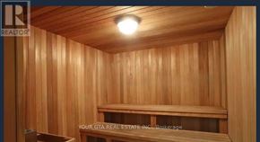 Toronto (Islington-City Centre West) condo for rent - A wooden sauna room with a bench and a light on the ceiling.