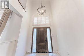 Oakville (Jc Joshua Creek) apartment for rent - A white hallway with a wooden door and a hanging light fixture.