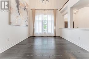 Oakville (Jc Joshua Creek) apartment for rent - A spacious room with a large painting on the wall and a view of greenery outside the window.