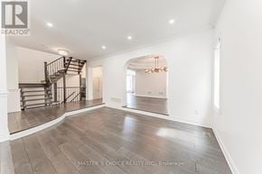 Oakville (Jc Joshua Creek) apartment for rent - A spacious room with a staircase and a chandelier.