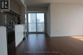 Toronto (Waterfront Communities) condo for rent - A modern kitchen with dark wood floors and a large window.