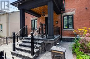 Brampton (Downtown Brampton) apartment for rent - A red brick house with a black railing and a wooden porch.